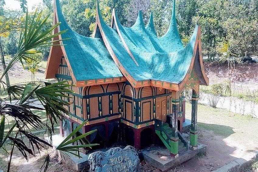 A model of a traditional house with a green roof and wooden structure. 4