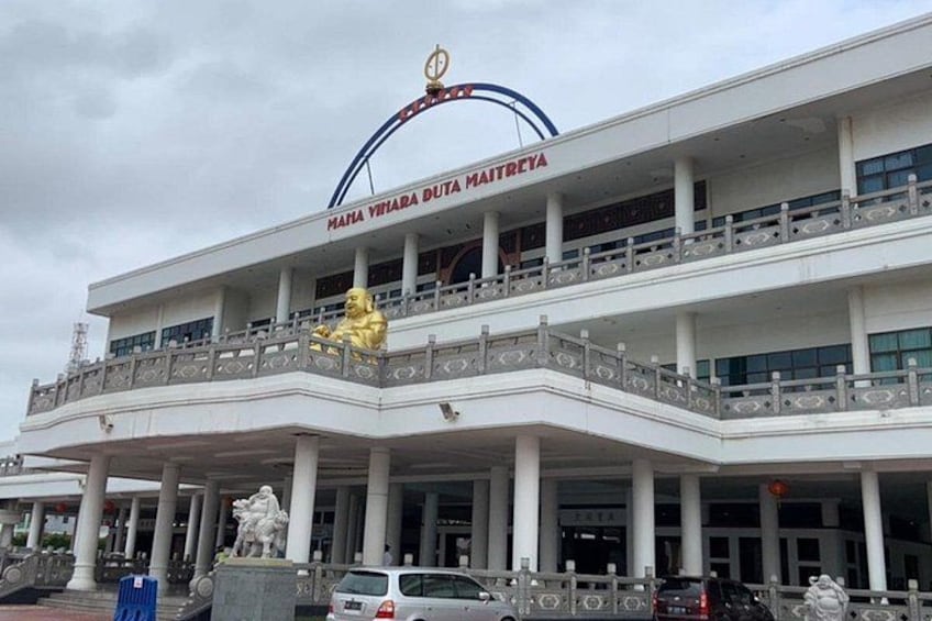 A multi-story building with a prominent golden statue on the ground floor. 3