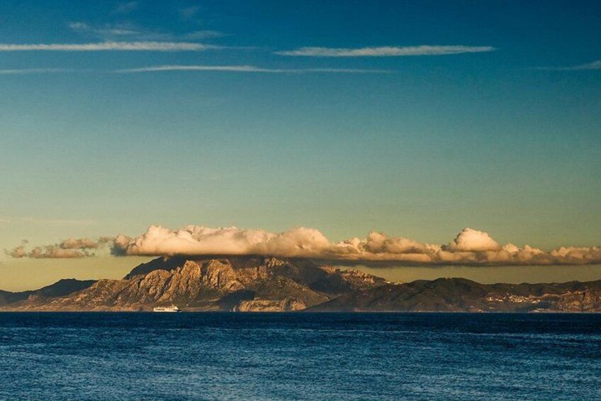 A mountain range, a body of water, and a boat. 1
