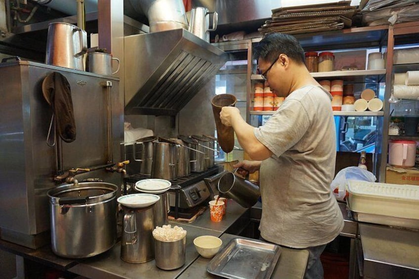 Un chef dans une cuisine professionnelle équipée d’appareils en acier inoxydable, de casseroles et d’ustensiles de cuisine. 5