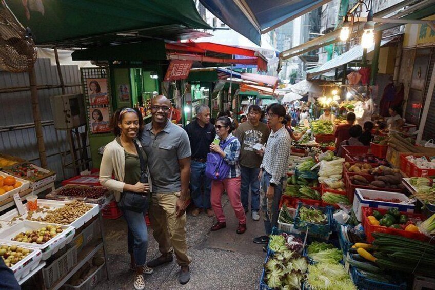 Un marché animé où l’on trouve de nombreux étals vendant des fruits et des légumes. 2