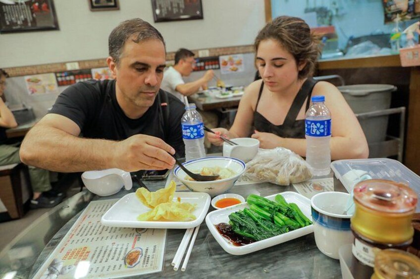 Une scène de restaurant avec des clients qui déjeunent ou dînent, un menu et divers plats, notamment des légumes et un bol de soupe. 2