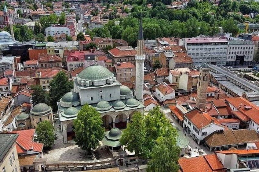 A cityscape with a prominent mosque featuring multiple domes and a tall minaret. 4