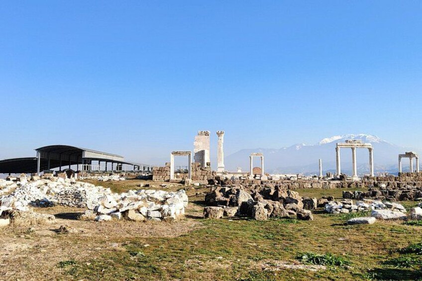 Ancient ruins with columns and a mountain in the background. 2