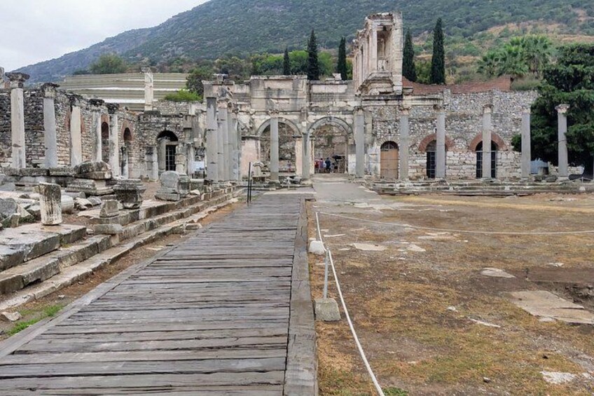 Ancient ruins with stone columns and an arched entrance. 2
