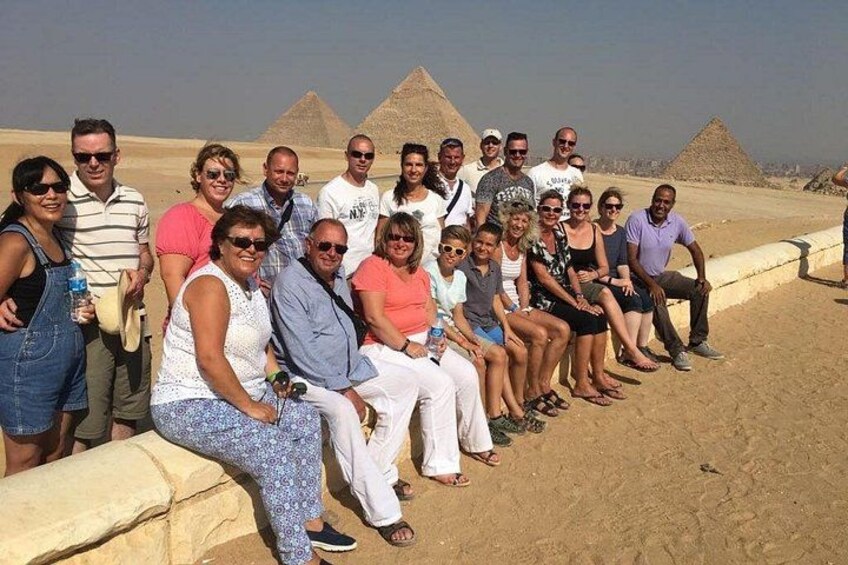 A group of people posing in front of pyramids. 5