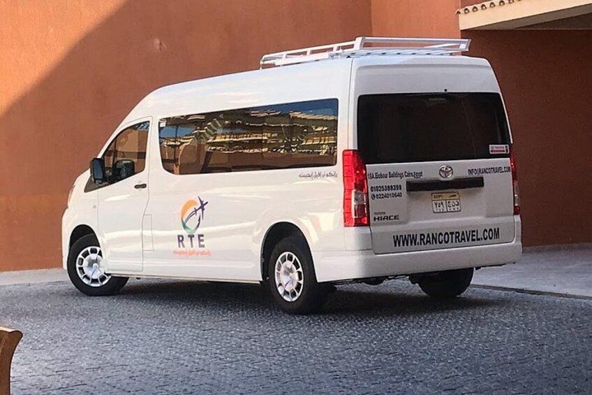 A white van parked in front of a building with a website address on the side. 3