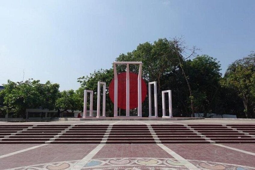 A red circular structure with white pillars in an open area with patterned flooring. 3
