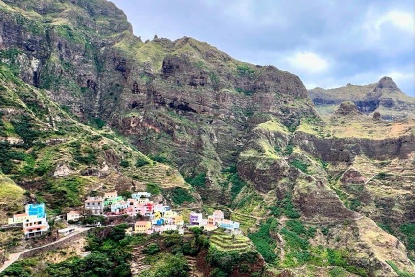 A mountainous landscape with terraced fields and colorful buildings nestled among the hills. 2