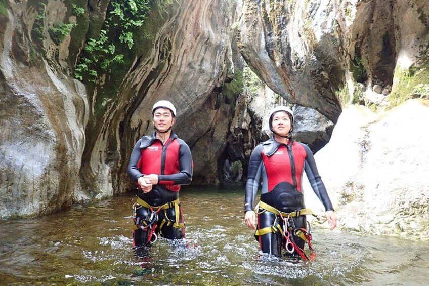 Deux personnes se trouvent dans une grotte où il y a de l’eau. Elles portent des gilets de sauvetage et des harnais. 3