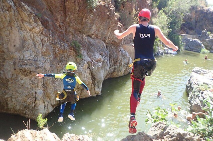Deux personnes sautent d’une falaise rocheuse et plongent dans une rivière. 5