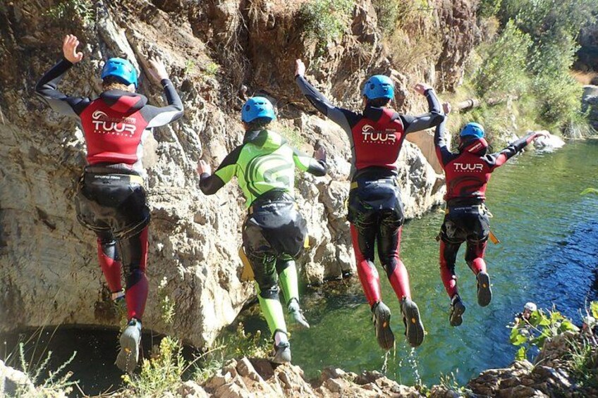 Quatre personnes sautent d’une falaise dans une rivière. 2