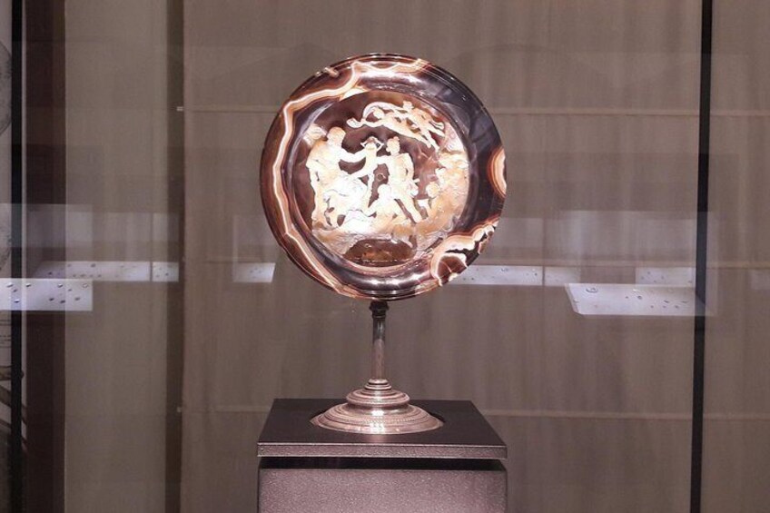 A metallic sculpture with intricate designs on a pedestal. 5