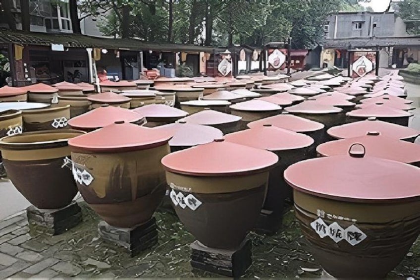 Large ceramic pots lined up on a cobblestone street. 2