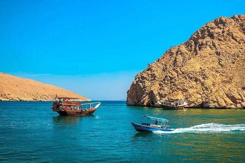 Two boats on a calm sea with rocky cliffs in the background. 3