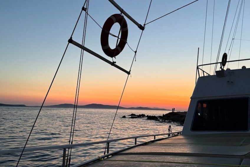 A boat at sunset with a lifebuoy and a distant shoreline. 4