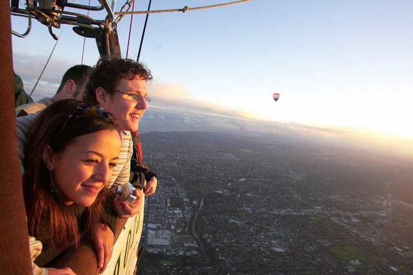 A hot air balloon flight with passengers and a cityscape below. 2