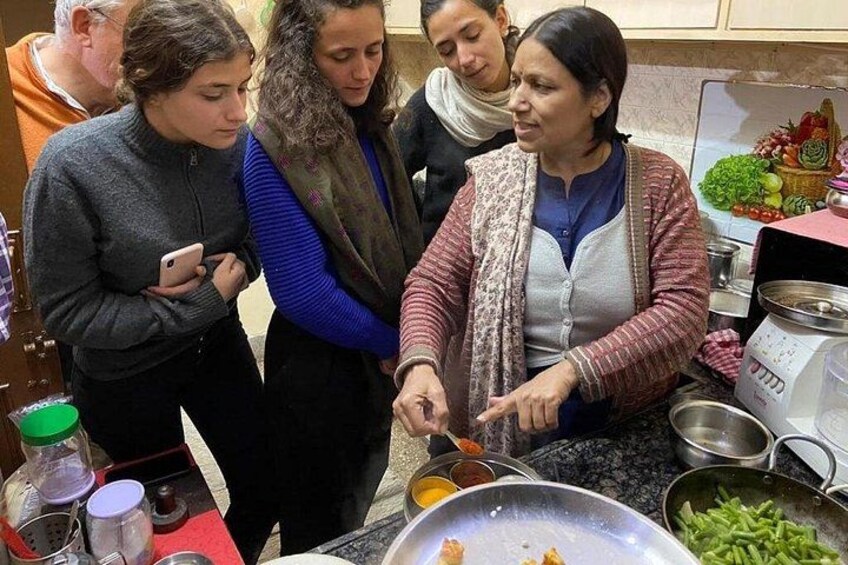 Een groep mensen kookt samen in een keuken. 1