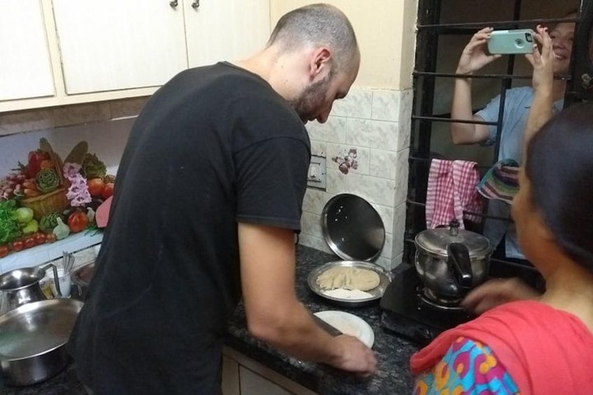A person preparing food in a kitchen with a pot on the stove and vegetables on the counter. 2