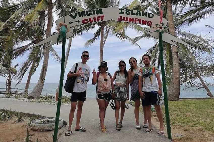 A group of people standing under a sign that reads 'Virgin Island Cliff Jumping.' 4