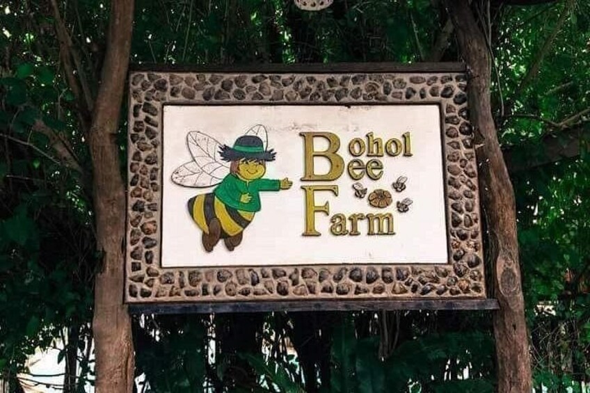 Skilt for Bohol Bee Farm med illustration af en bi og en stenframing. 4