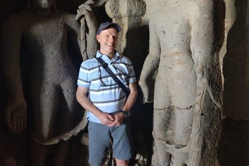 A person standing in front of a large stone sculpture. 2