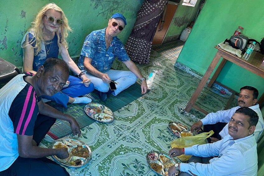 Un grupo de personas sentadas en el suelo, comiendo. 2