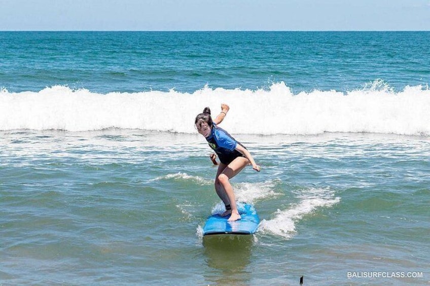 A person surfing on a blue board in the ocean. 5