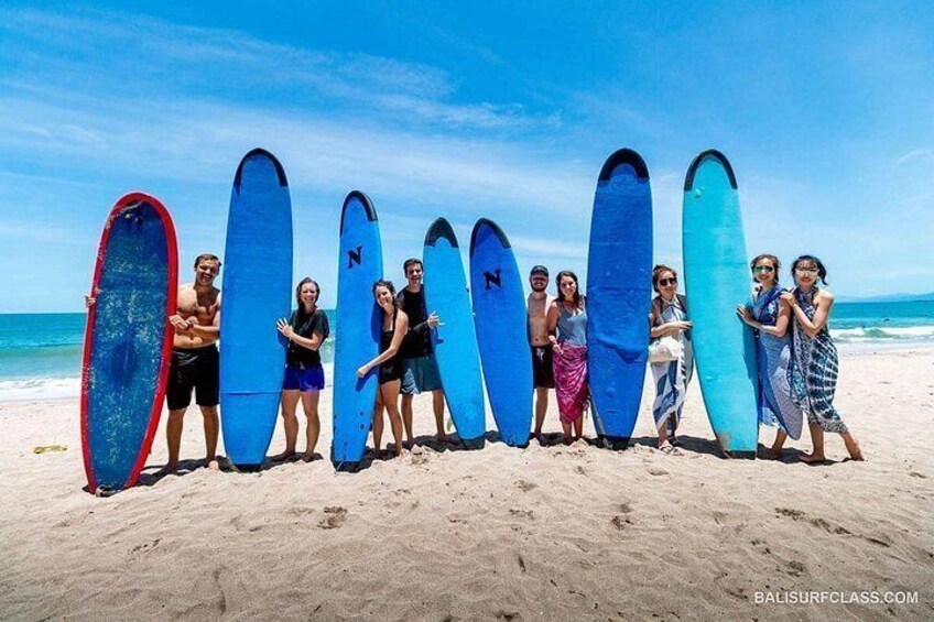 A group of people holding surfboards on a beach. 2