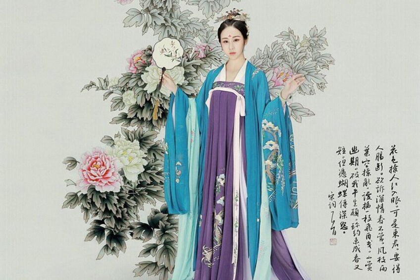 A person in traditional attire with floral patterns, holding a fan. 1
