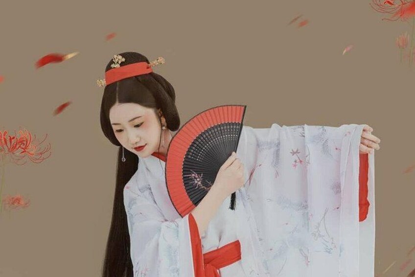 A person in traditional attire holding a fan. 2