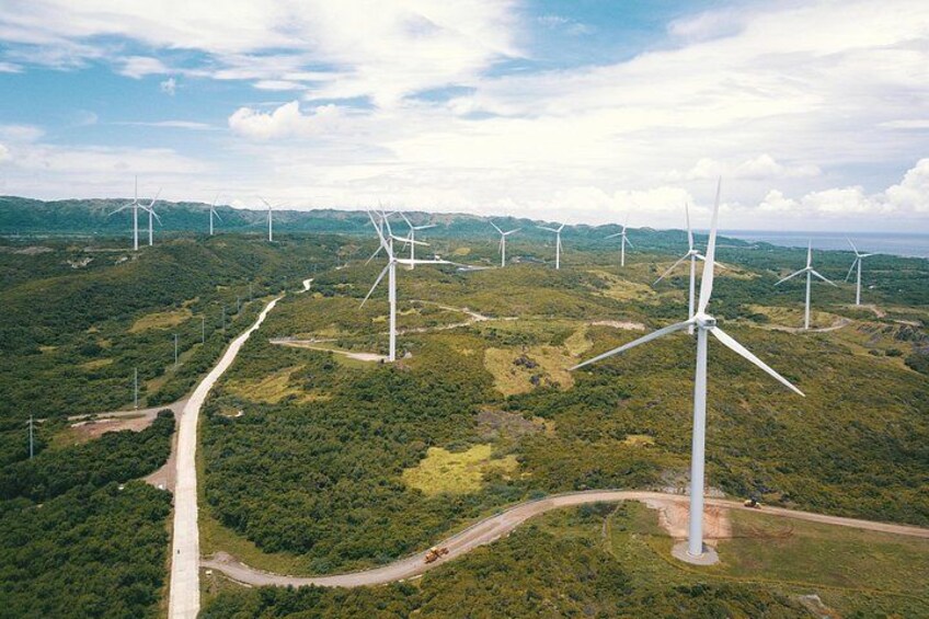 A wind farm with multiple wind turbines in a hilly landscape. 3