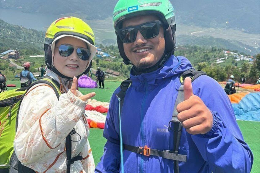 Two people wearing helmets and jackets, with a mountainous landscape in the background. 5
