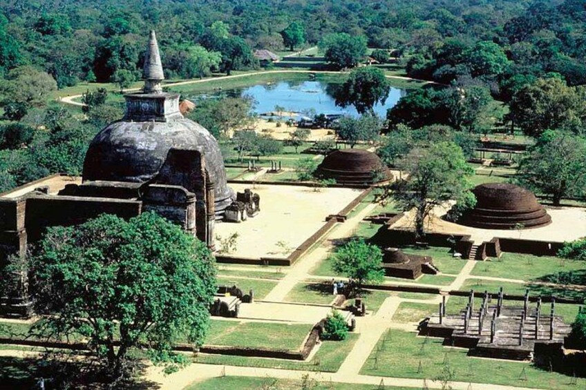 A large temple complex with a prominent dome and smaller structures, surrounded by lush greenery and a body of water. 1