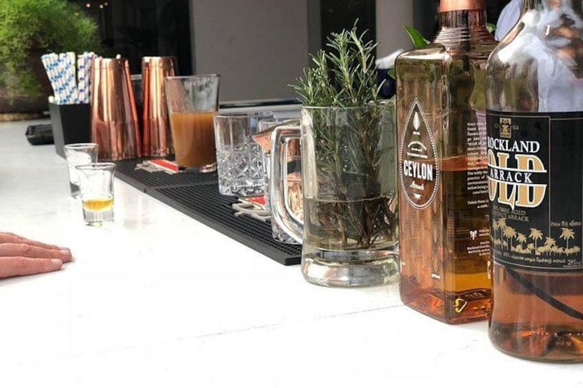A bar setup with various bottles, glasses, and copper mugs. 1