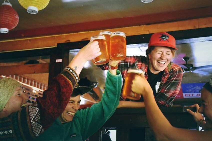 People toasting with beer mugs in a bar setting. 3