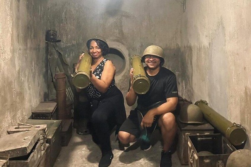 Twee personen zitten in een kleine ruimte met grote, cilindervormige voorwerpen. 2