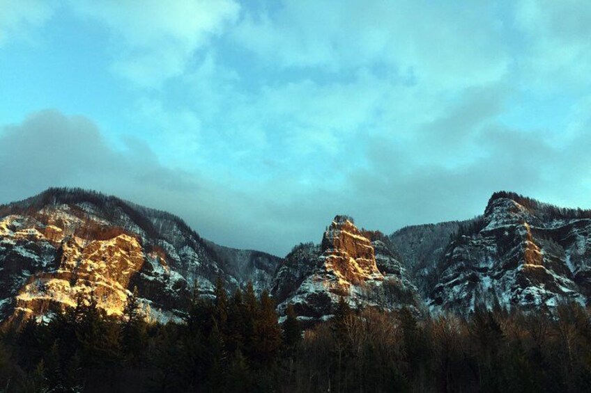 A mountainous landscape with snow-covered peaks and a forested foreground. 5