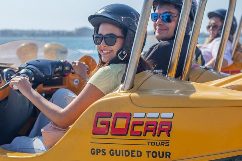 Ett gult fordon med texten ”GO CAR TOURS” och ”GPS-GUIDAD TUR” påskrivet. 2