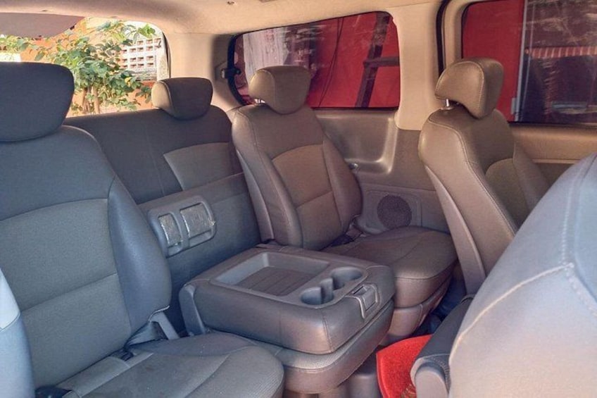A car interior with grey leather seats, a central console, and a rearview mirror. 5