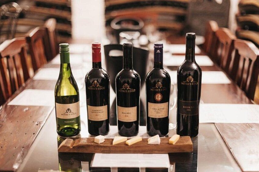 A row of wine bottles on a wooden table in a restaurant. 2