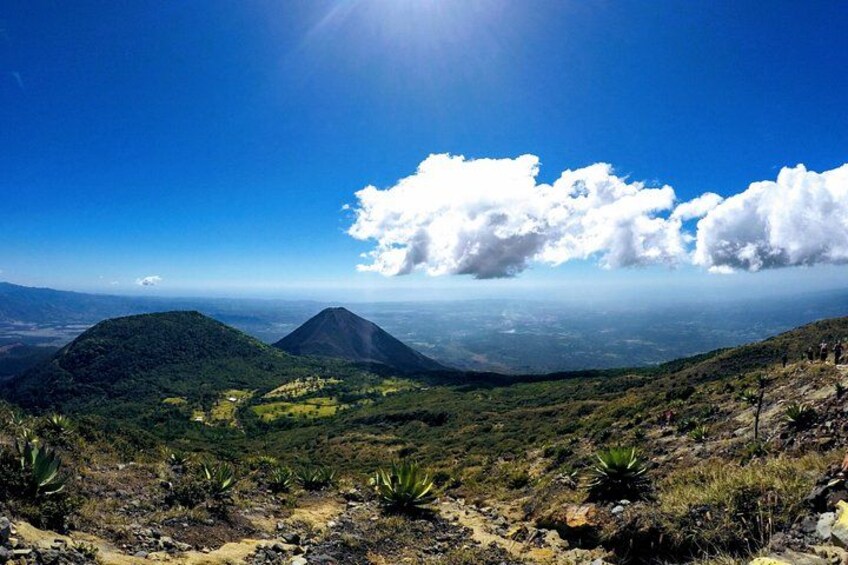 A mountainous landscape with a prominent volcano and a clear blue sky. 4