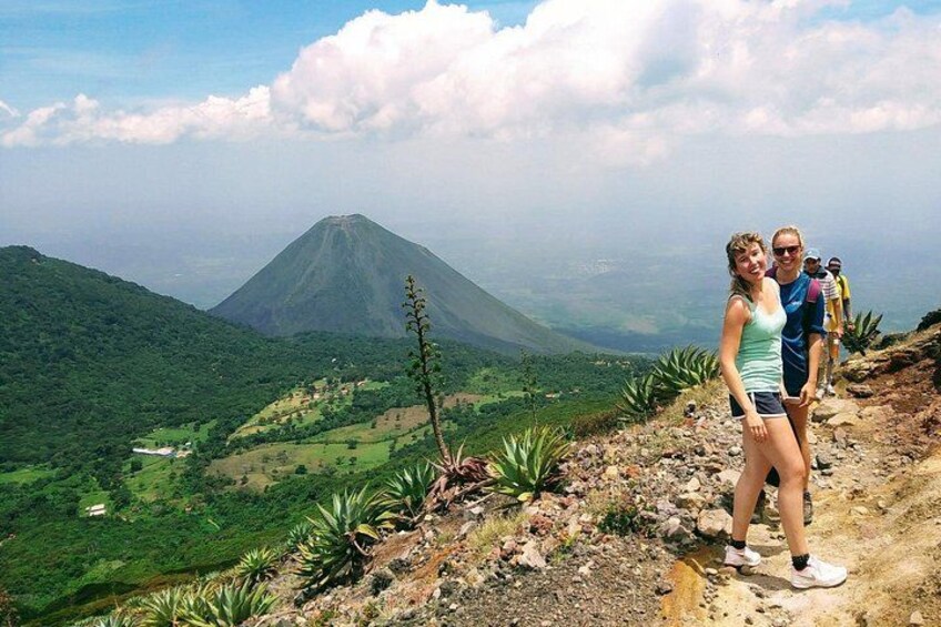 A mountainous landscape with a volcano in the background, lush greenery, and a clear sky. 5