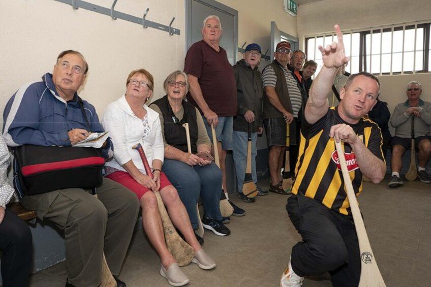 A group of people sitting and standing in a room, some holding walking sticks. 3