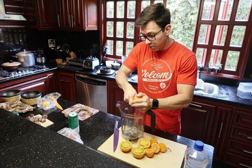 A person in a red shirt preparing food in a kitchen with wooden cabinets and a window. 1