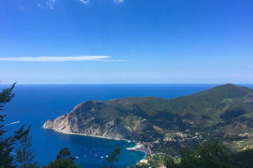 A coastal landscape with a clear blue sea, a mountainous terrain, and a small settlement near the shore. 4