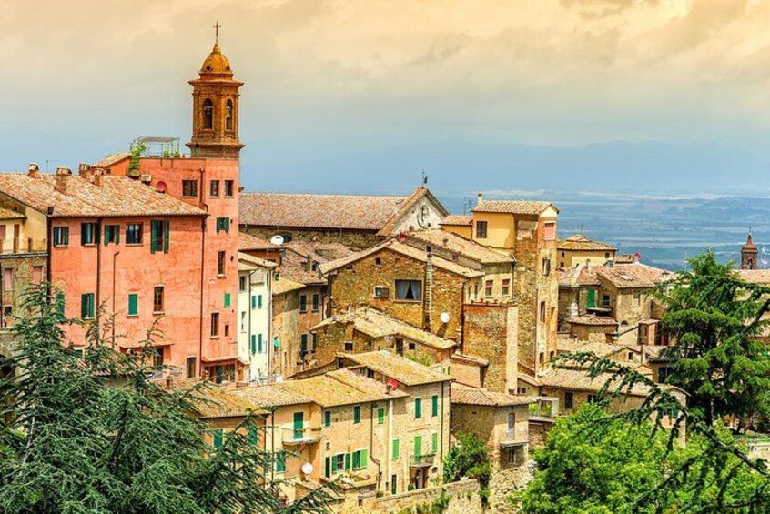 Une ville historique aux bâtiments aux couleurs vives, dotée d’un imposant clocher et située dans un cadre montagneux. 2