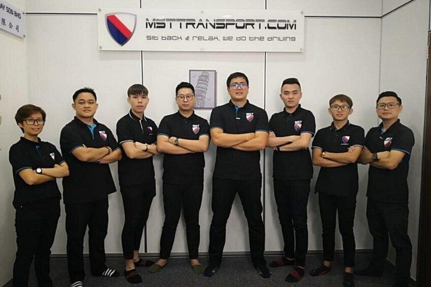 A group of people in black uniforms standing in a room with a sign above them. 3