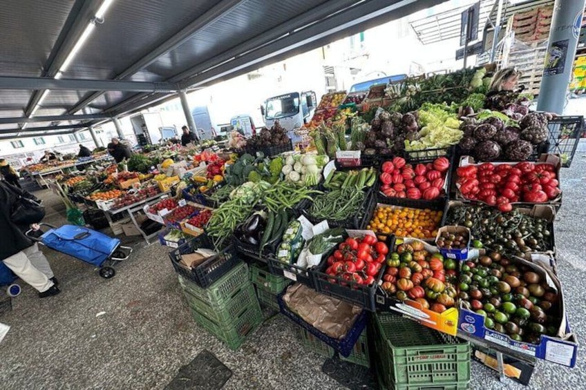 Ein Markt mit verschiedenen Gemüsesorten und Früchten, präsentiert in Kisten. 3