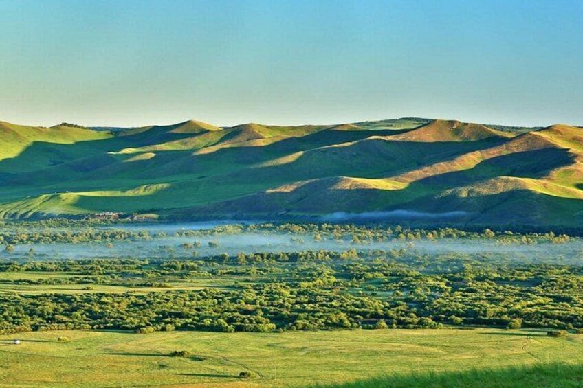 Rolling hills, a lake, and a forested area. 2